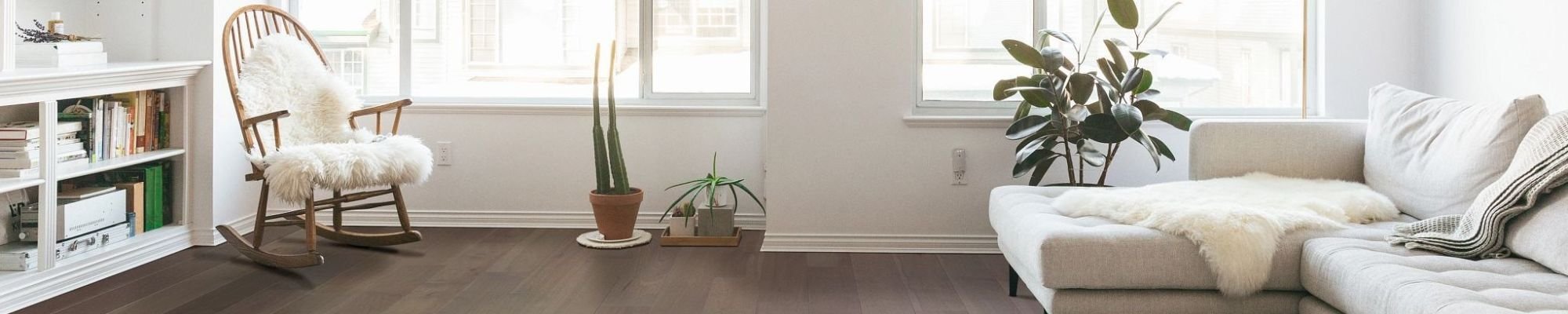 Beige couch and white armchair on brown hardwood floor from Dishman Flooring on Houma, LA area